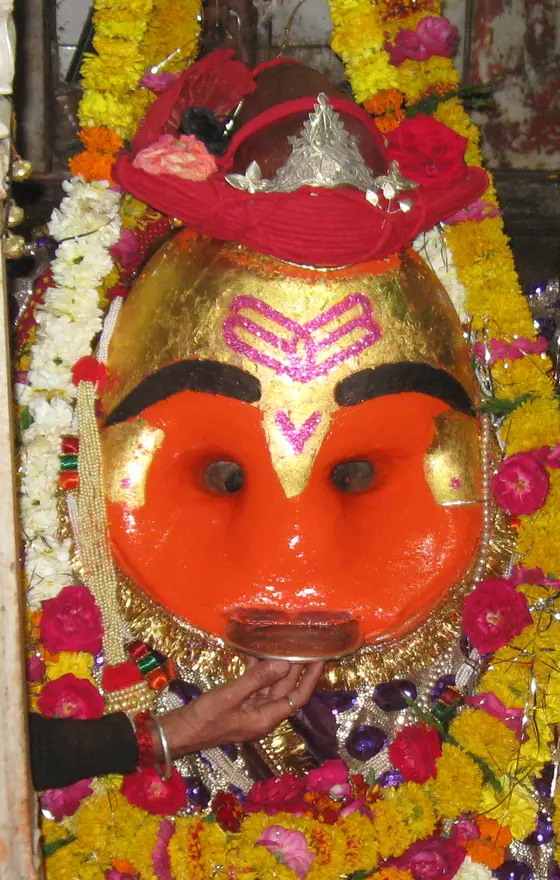 Shri Kal Bhairav adorned with vermilion, flowers and the Maratha-style turban (detail cropped from a larger photograph)